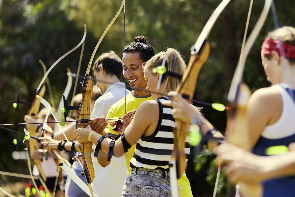 Viesi piedalās loka šaušanas nodarbībā pie Magic Life Jacaranda.