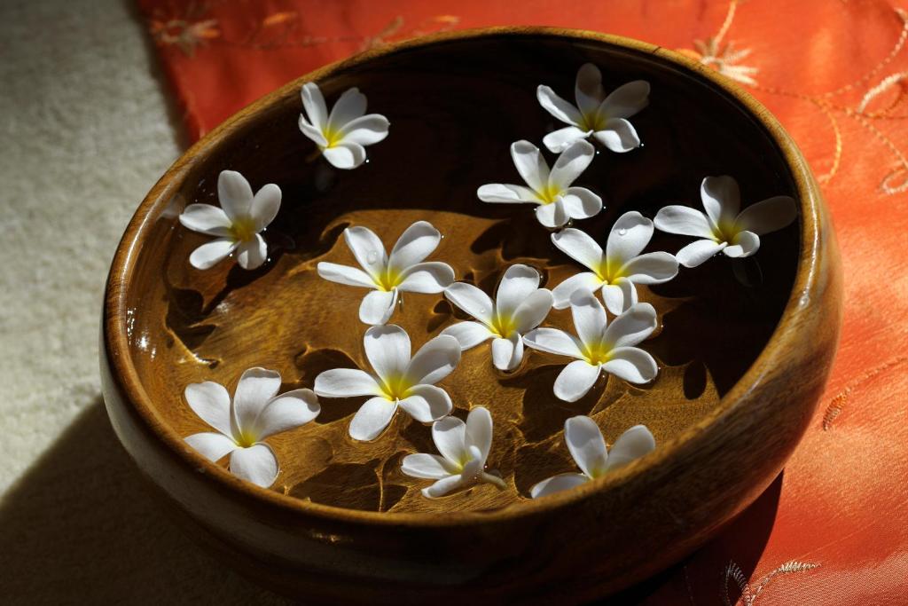 Plumerijas ziedi koka bļodā viesnīcā Crowne Plaza Dubai Jumeirah