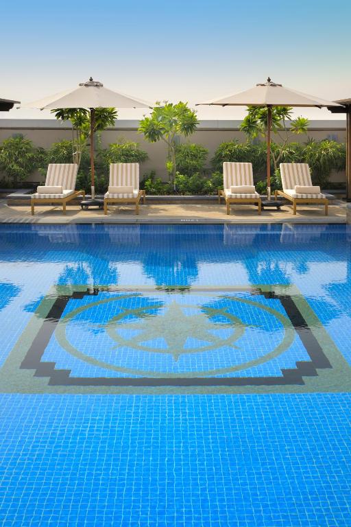 Peldbaseins ar atpūtas krēsliem Crowne Plaza Dubai Jumeirah.