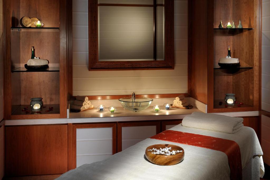 Spa zona viesnīcā Crowne Plaza Dubai Jumeirah ar masāžas gultu un svecēm.