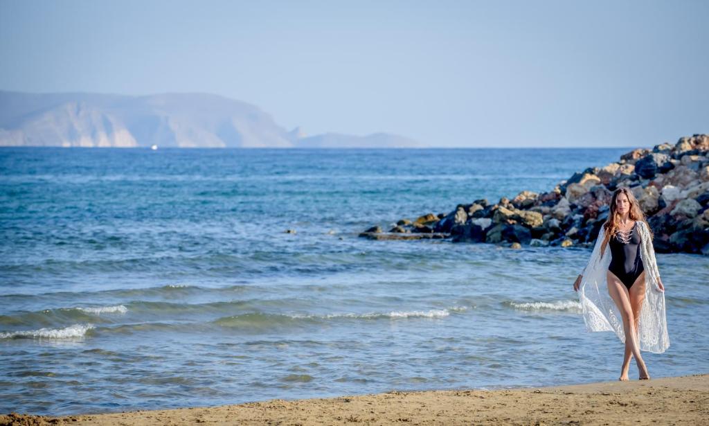 Sieviete pludmalē pie Sol Marina Beach Crete, izbaudot sauli un jūru.