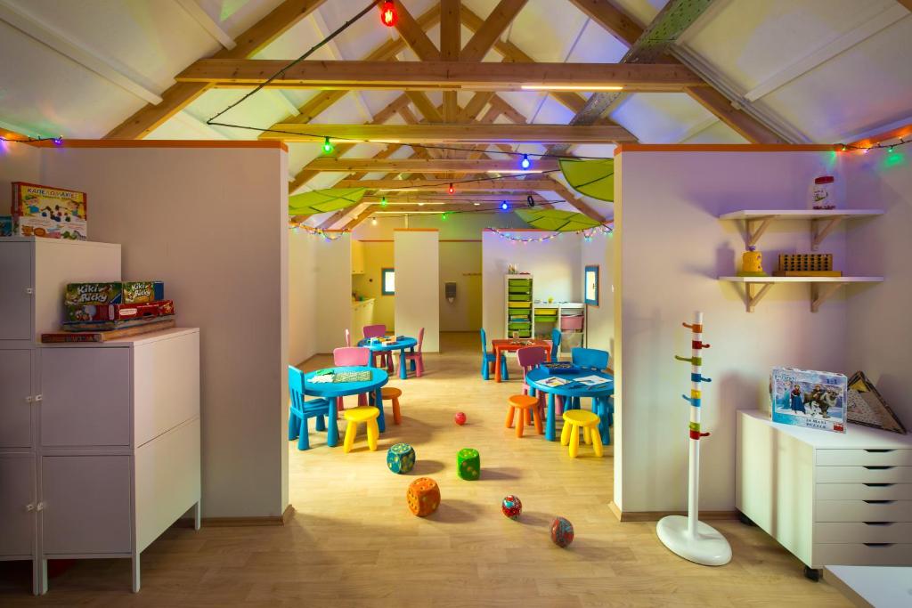 Bērnu rotaļu telpa Fodele Beach & Water Park Resort ar krāsainiem galdiem un rotaļlietām.