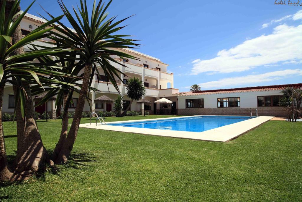 Viesnīca ar peldbaseinu un zaļu zālienu, apstādījumi ar palmām un sauļošanās krēsliem. Ideāla vieta relaksācijai un brīvdienām.