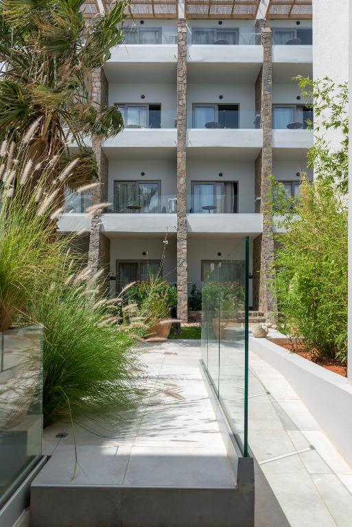 Grezns skats uz Elounda Orama numuriem piekrastē ar zaļo apstādījumu.