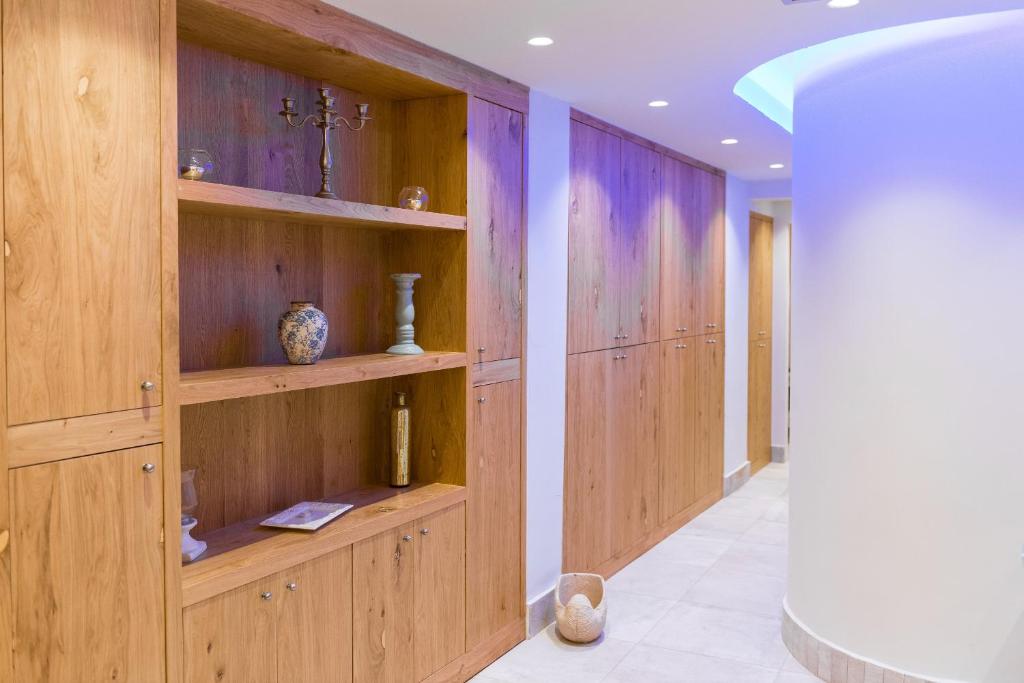 Elegants koka interjers viesnīcā Elounda Orama, gaišs koridors ar plauktiem.