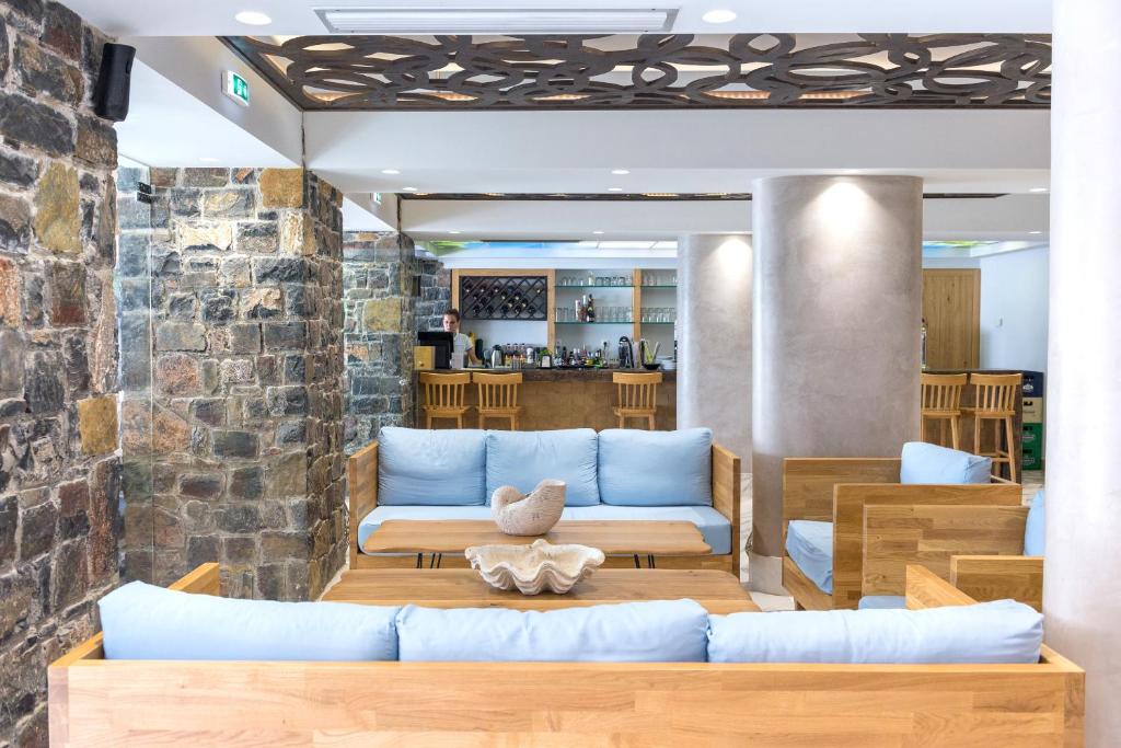 Mūsdienīgs viesnīcas Elounda Orama interjers ar akmens sienām un koka mēbelēm.