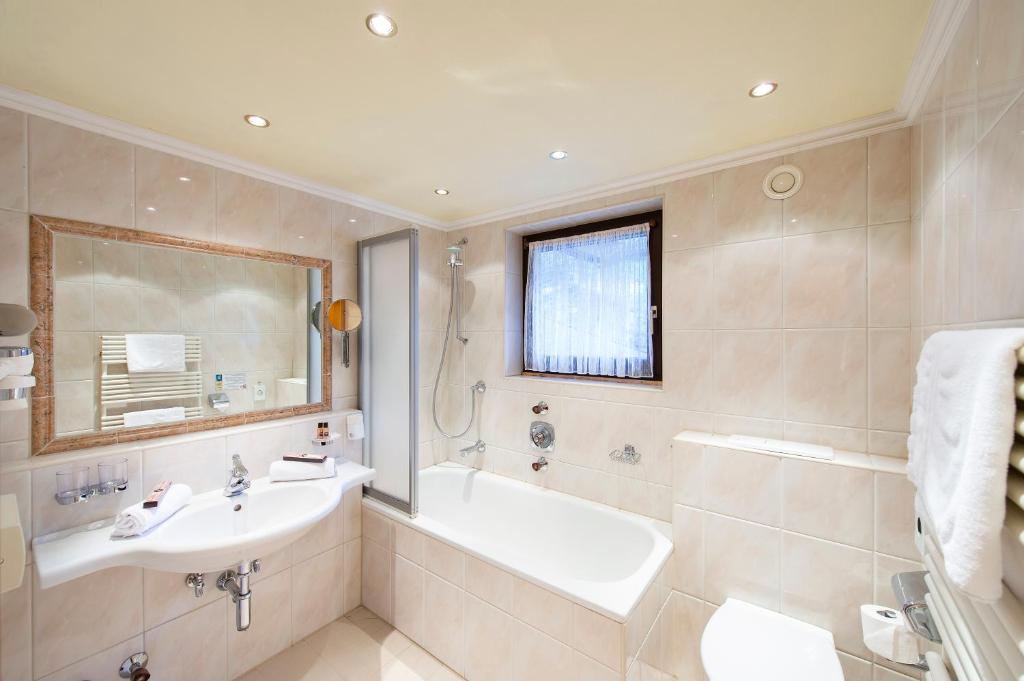 Mūsdienīgs vannas istabas interjers ar vannu un dušu, labiekārtots ar gaismas avotiem un spoguļiem. Eleganta un tīra dizaina atmosfēra.