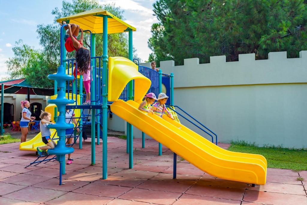 Bērni spēlējas uz rotaļu laukuma Starlight Resort, kāpelējot un slīdot.