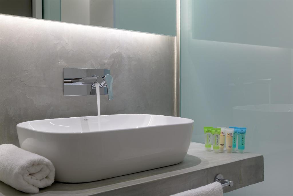 Mūsdienīgs vannas istabas izskats ar elegantu izlietni un higiēnas līdzekļu komplektu. Gaiša krāsu palete un minimālisma dizains rada relaksējošu atmosfēru.