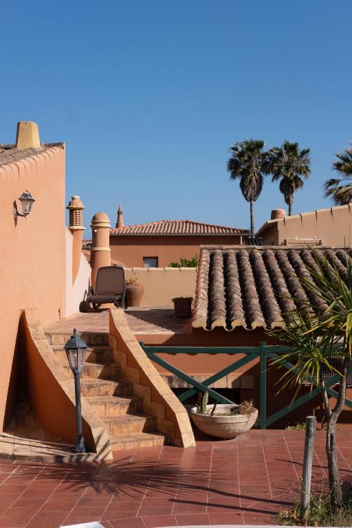 Quinta do Mar Country & Sea Village kāpnes pie viesnīcas ar palmām un zilo debesīm