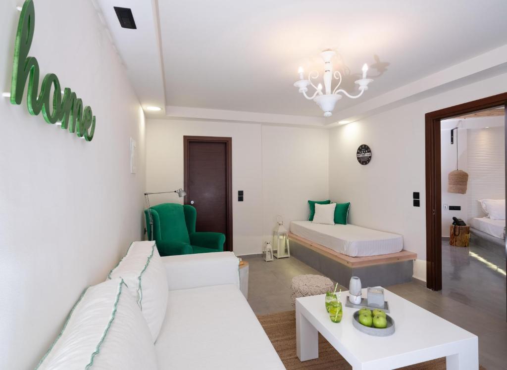 Mūsdienīgs numurs Eva Mare Hotel & Suites ar zaļu krēslu un viesistabu.