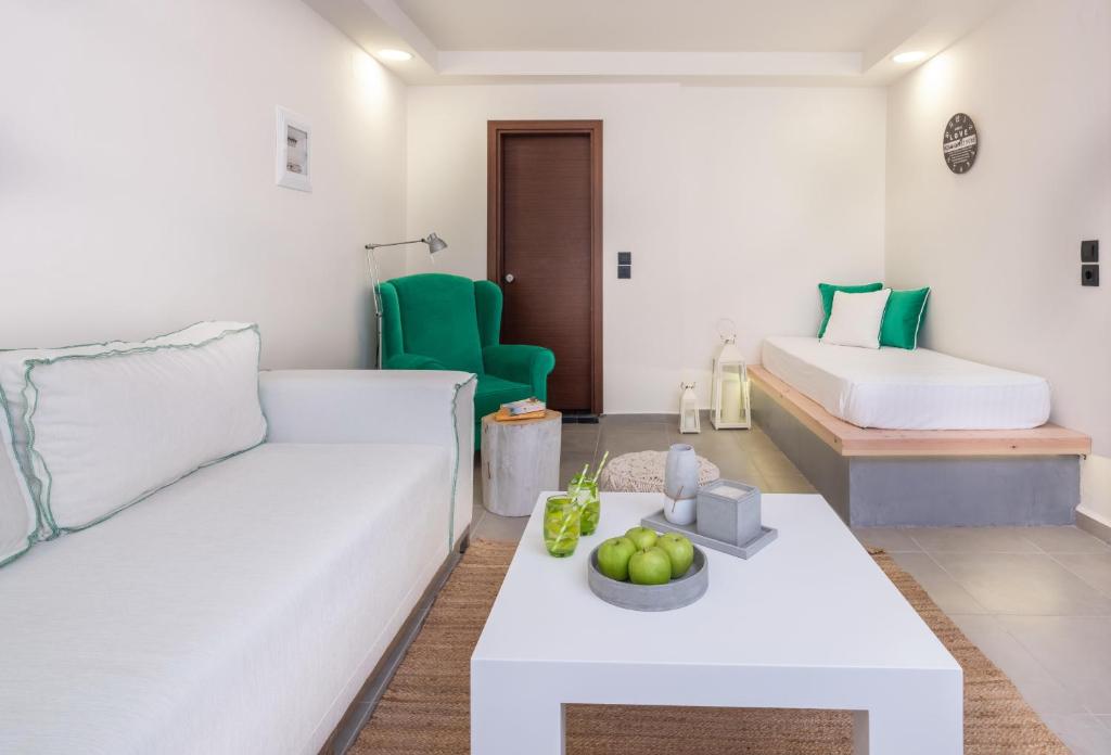 Mūsdienīgs numurs Eva Mare Hotel & Suites ar zaļo krēslu un dabīgu apgaismojumu.
