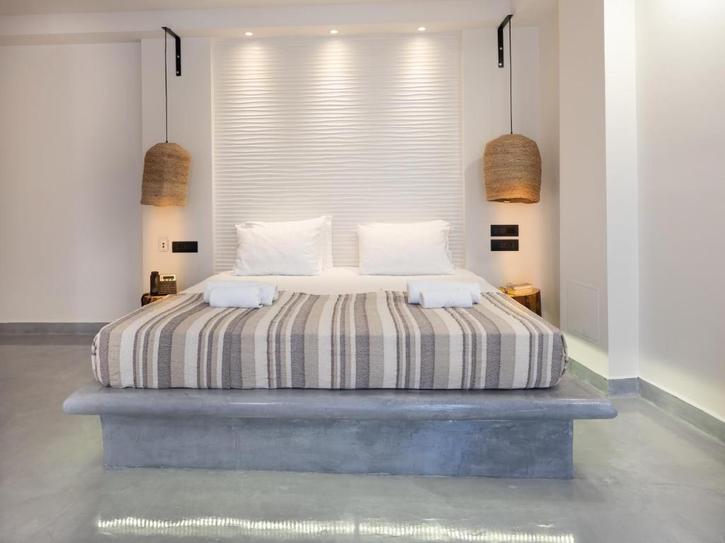 Mūsdienīgs numurs Eva Mare Hotel & Suites ar ērtu gultu un maigu apgaismojumu.