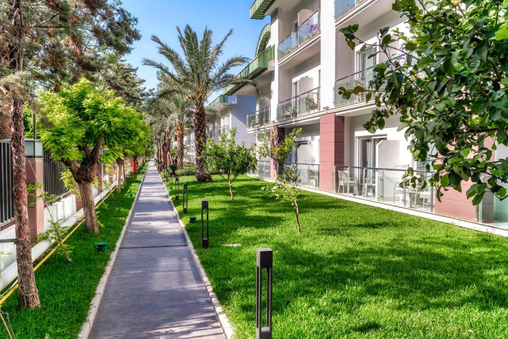 Zaļš zālienis un pastaigu celiņš viesnīcā Corendon Playa Kemer