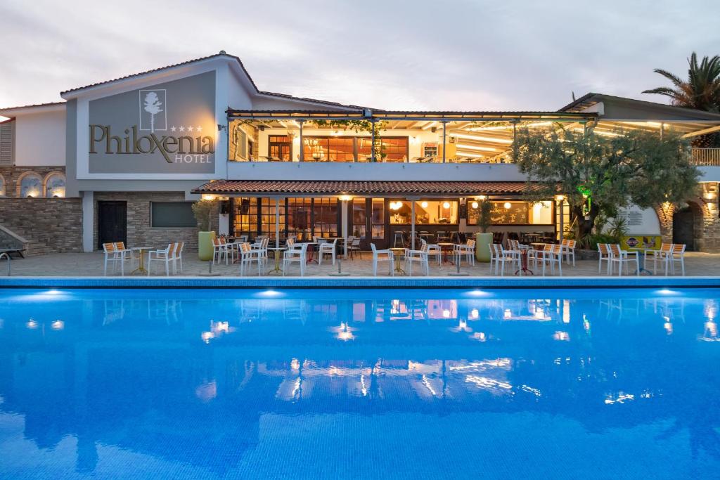 Philoxenia viesnīca ar plašu terasi un baseinu, kas atspoguļojas ūdenī. Viesnīca piedāvā komfortablu atpūtu un ēdināšanas iespējas.
