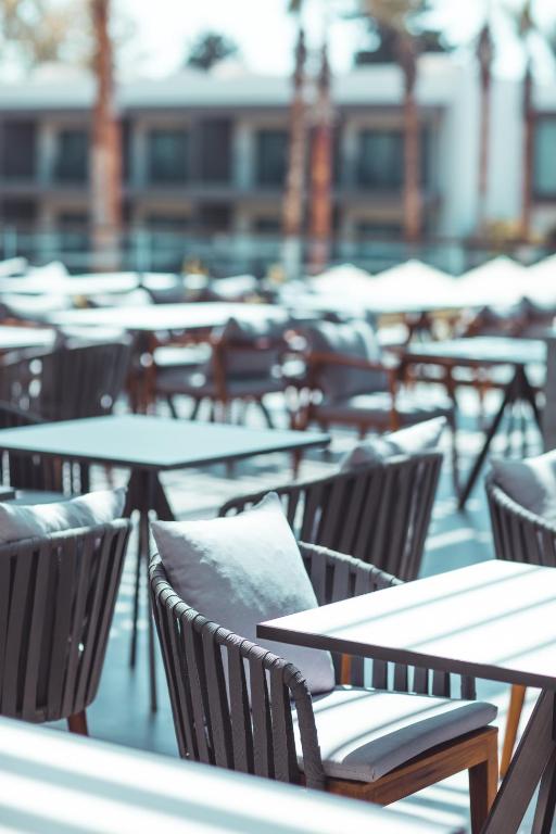 Terases zona ar koka galdiem un krēsliem viesnīcā Paloma Orenda.