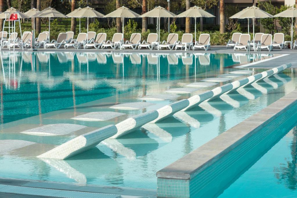 Baseins ar saules krēsliem pie viesnīcas Paloma Orenda