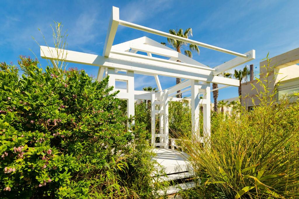 Baltā pergola starp zaļumiem La Blanche Resort & Spa