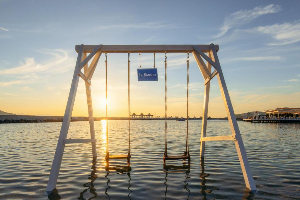 Šūpuļtīkls pie La Blanche Resort & Spa saulrieta laikā piekrastē