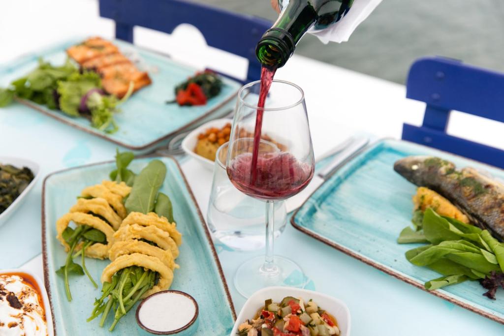 Vīna pudele tiek pasniegta pie galda ar gardām maltītēm La Blanche Resort & Spa.