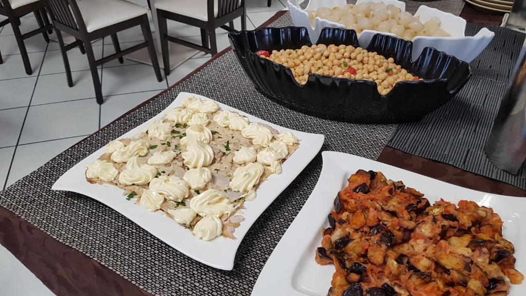 Galda klāšana ar dažādām uzkodām, ieskaitot krēmīgu vistas salātu trauku, dārzeņu salātus un maizes cepumus. Eleganta prezentācija svinīgai pasākumam.