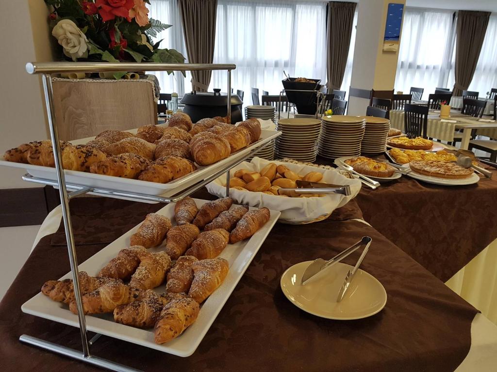 Broka ar dažādiem maizes izstrādājumiem, tostarp kruasāniem un saldajiem maizes gabaliņiem, kas tiek pasniegti svētku galdā. Svaiga un apetītlīga brokastu izvēle.