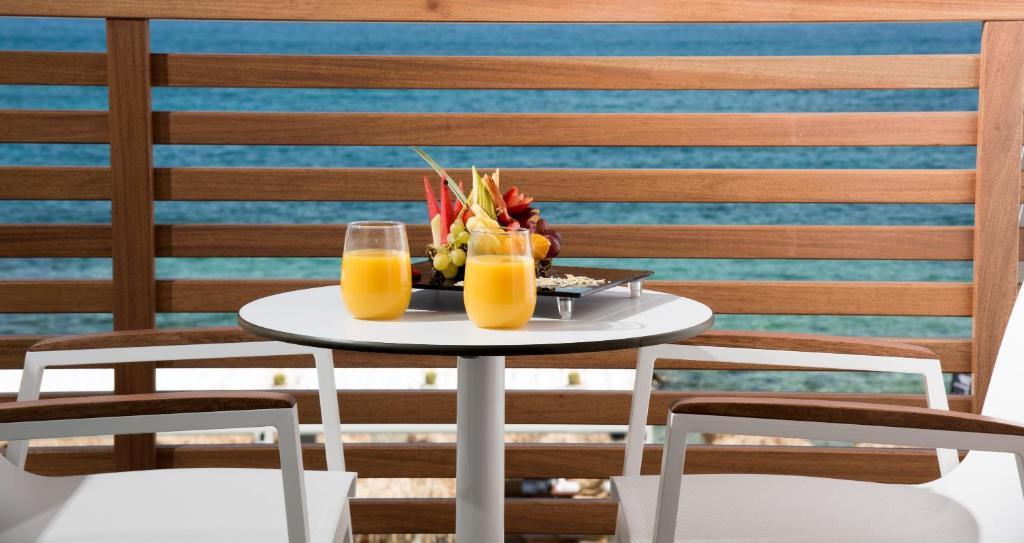 Enorme Ammos Beach Resort balkons ar dzērieniem un augļu šķīvi piekrastē