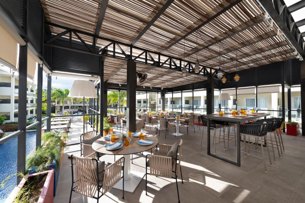 Mūsdienīgs restorāns ar plašu terasi, kurā ir elegantas mēbeles un skats uz baseinu. Viegla gaisotne un dabiskā apgaismojuma izmantošana rada patīkamu atmosfēru.