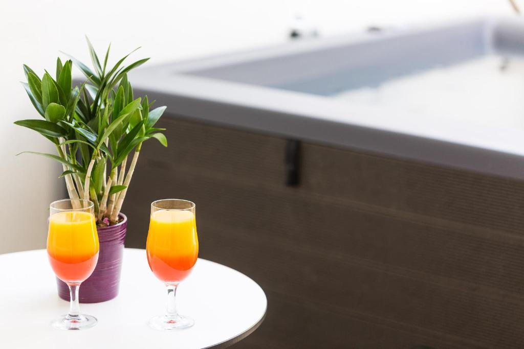 Divi kokteiļi pie galda pie Atrium Ambiance Hotel, blakus džakuzi.