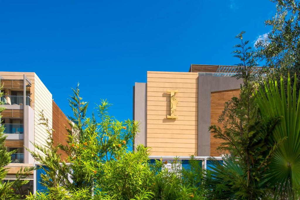 I-Resort Beach Hotel & Spa ēka starp zaļumiem pie saulainas debess