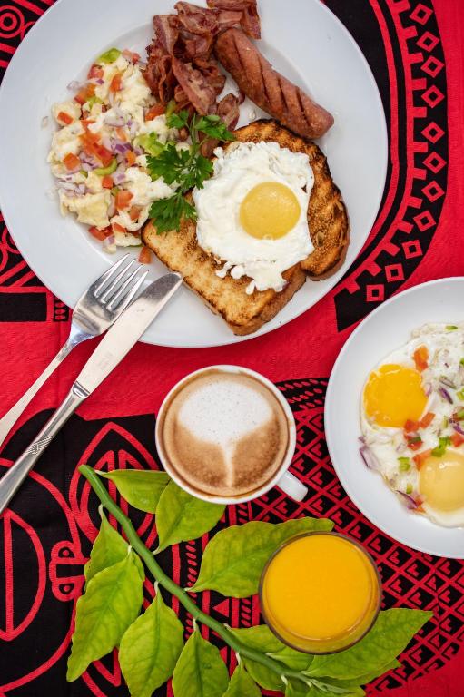 Zanzibar Queen brokastu šķīvis ar olu, gaļu un kafiju.