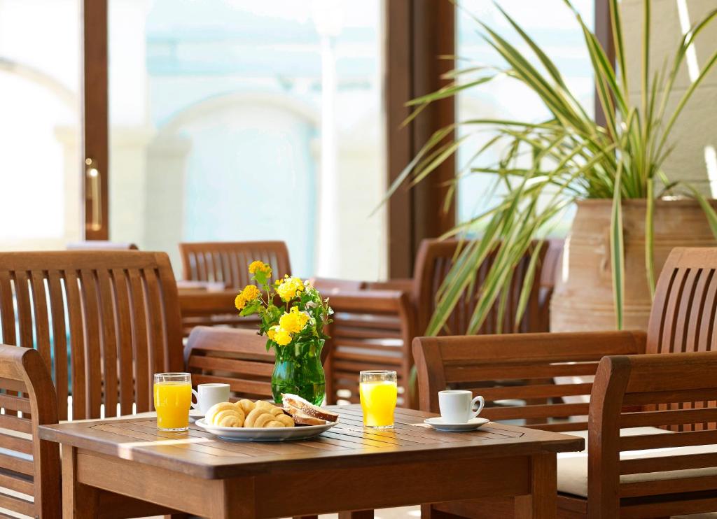 Mitsis La Vita Beach Hotel brokastu galda klāšana ar ziediem un dzērieniem