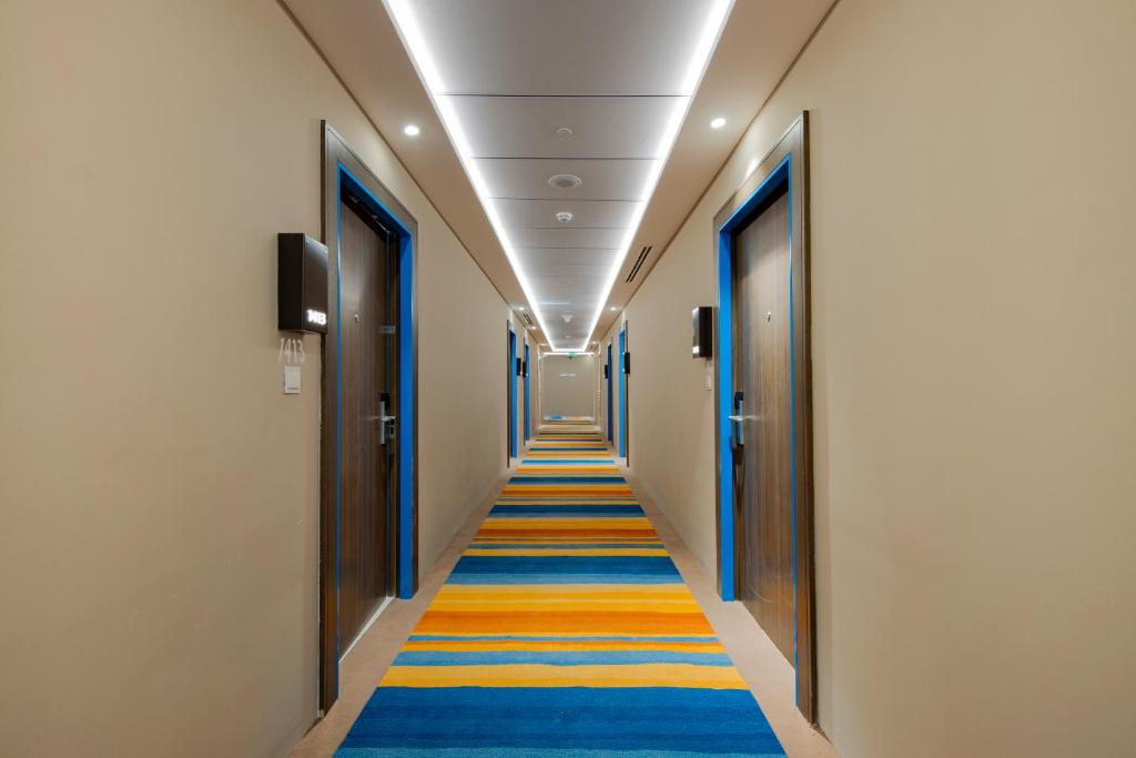 Citymax Business Bay viesnīcas koridors ar krāsainu paklāju.