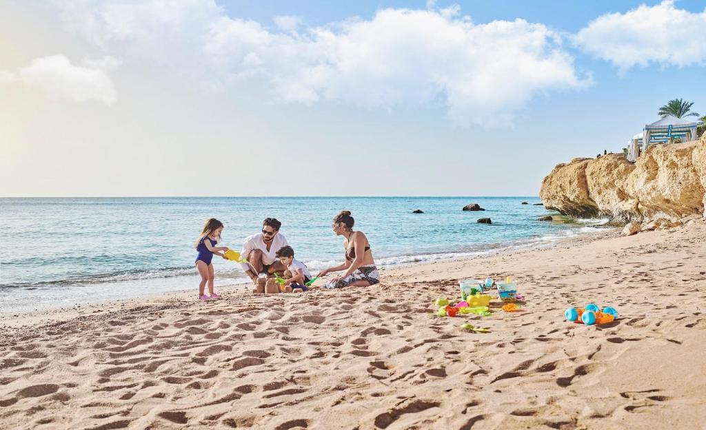 Ģimene būvē smilšu pilis Four Seasons Resort Sharm El Sheikh privātajā pludmalē