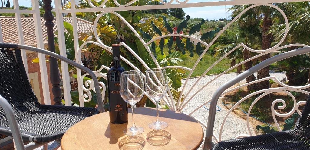 Balkons pie Quinta do Mar Country & Sea Village ar vīna pudeli un glāzēm.