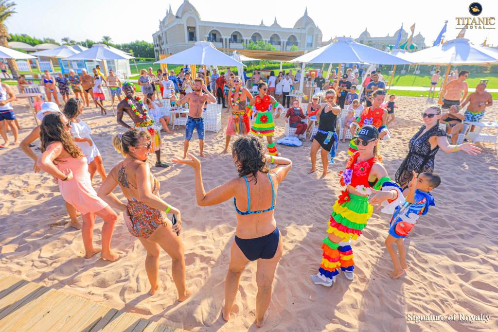 Viesnīcas Titanic Royal Resort viesi izklaidējas pludmalē ar deju un krāsainiem tērpiem.