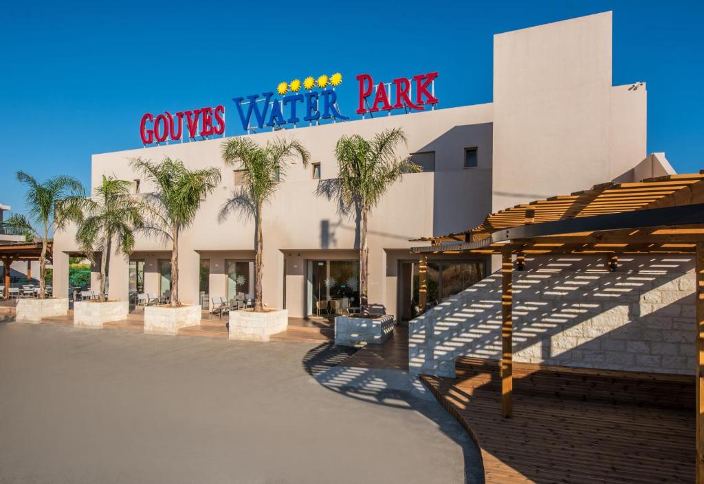Gouves Water Park viesnīcas eksterjers ar palmām un saulainu debesi.