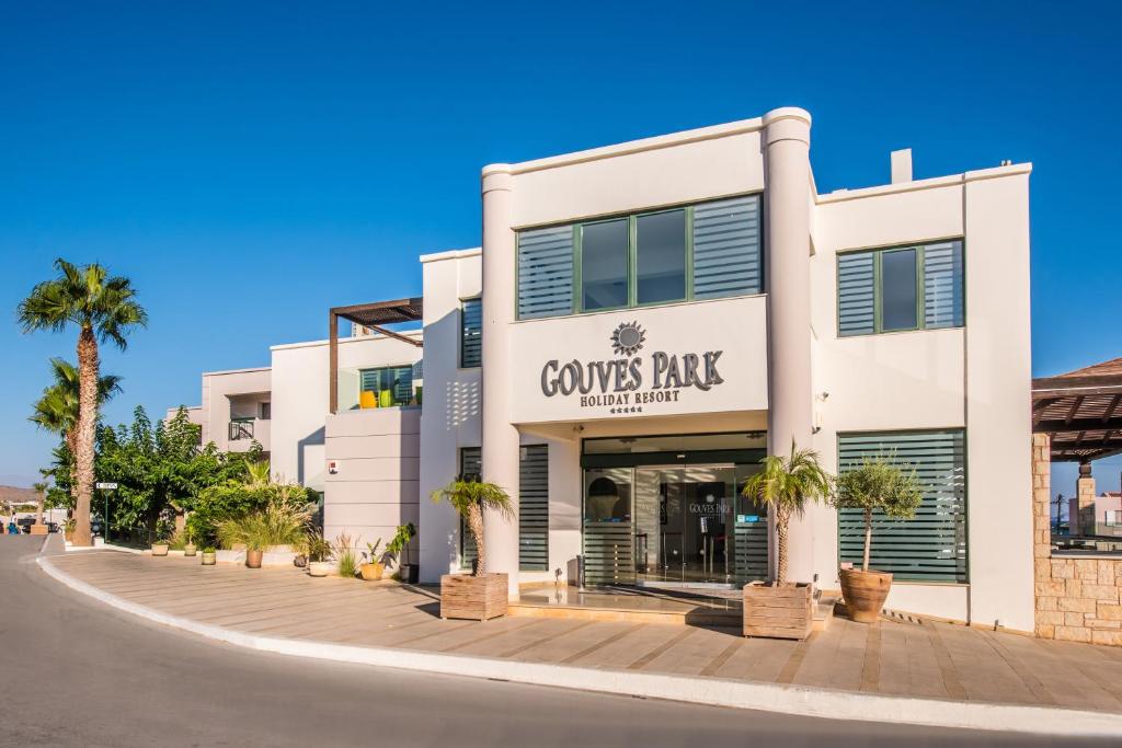Gouves Park Holiday Resort moderna ēka ar palmām un skaidru debesu fonā.