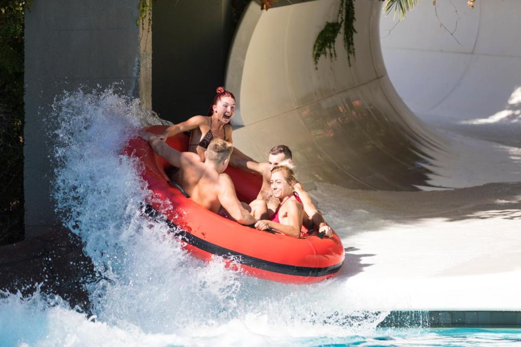 Četri cilvēki jautri slīd pa ūdens slidkalniņu Ali Bey Club