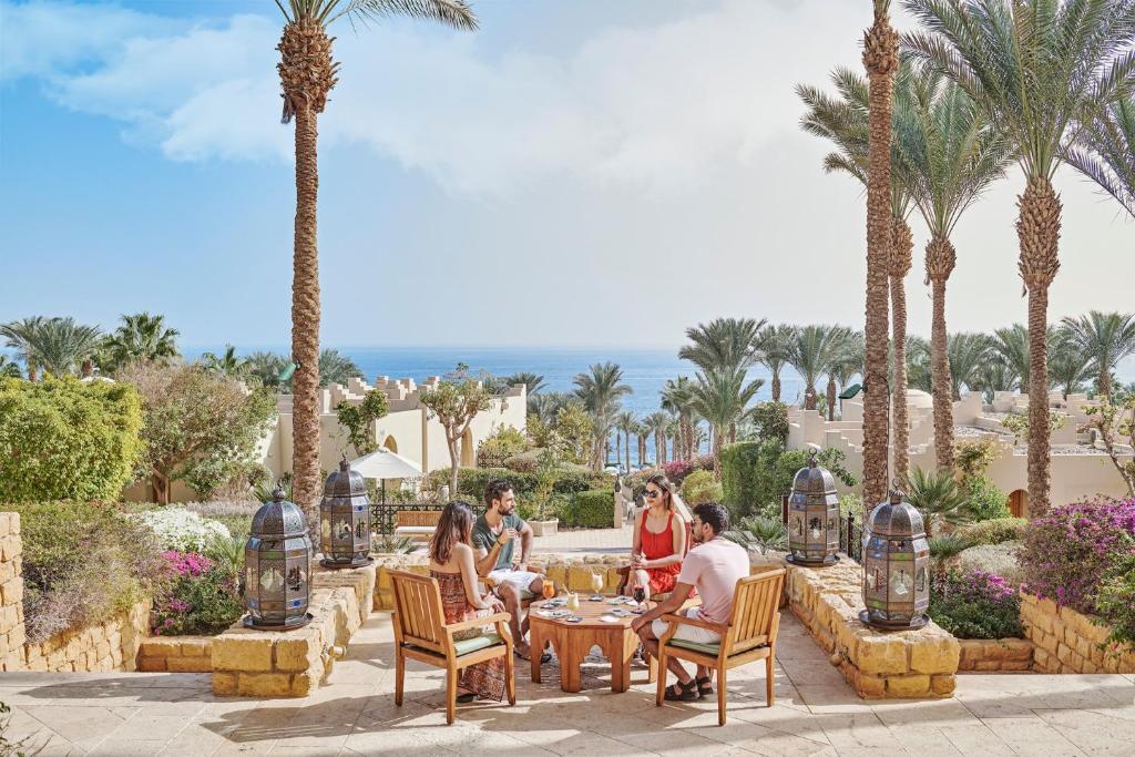 Draugu kompānija bauda atpūtu Four Seasons Resort Sharm El Sheikh terasē ar skatu uz jūru.