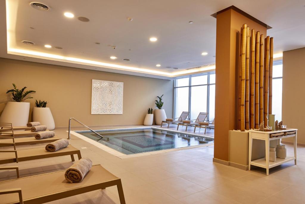 Mūsdienīgs spa interjers ar relaksējošu atmosfēru, iekārtots ar koka elementiem un baseinu. Ērti sauļošanās krēsli un zaļumi piešķir vietai svaigumu.