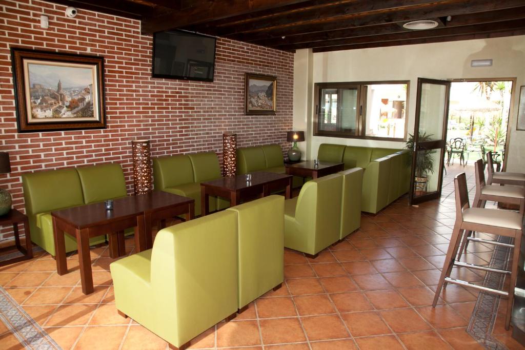 Mūsdienīgs kafijas veikals ar zaļām dīvānu grupām un koka galdiem, kas rada siltu un aicinošu atmosfēru. Interjeru papildina mākslas darbi uz sienām un liela loga skats uz āra terasi.