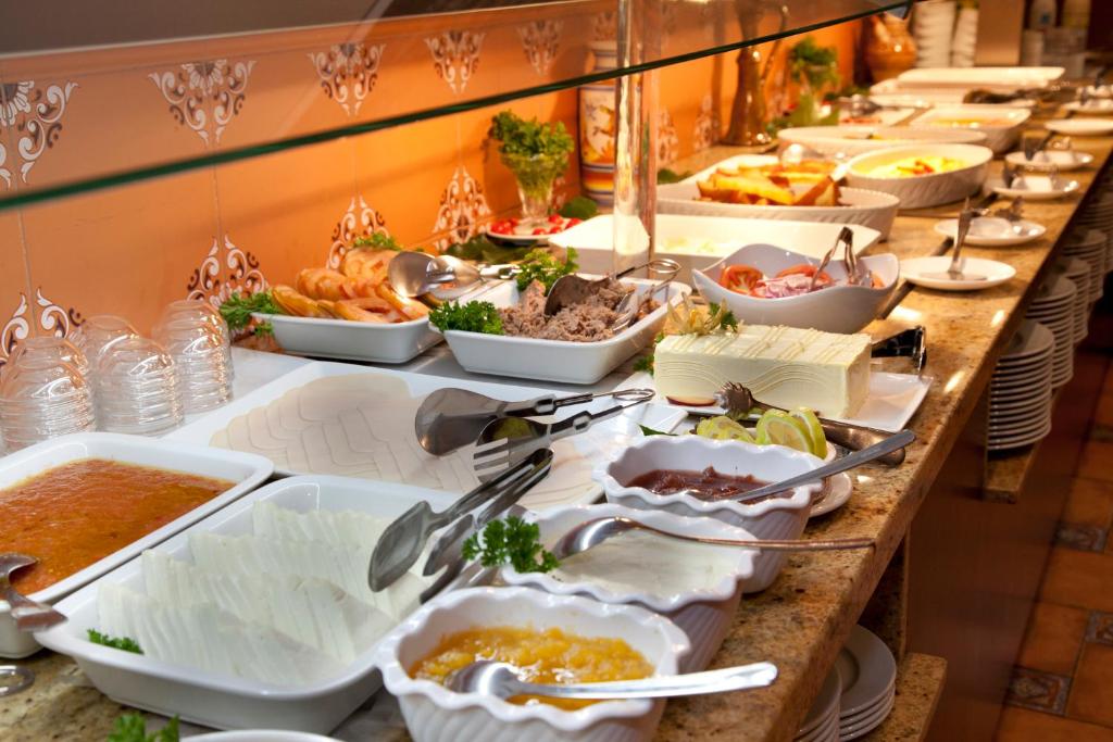 Pusdienu bufete ar dažādiem ēdieniem, tostarp salātiem, gaļas un dārzeņu uzkodām, mērču un desertu izvēli. Ideāla vieta, kur baudīt daudzveidīgu maltīti.