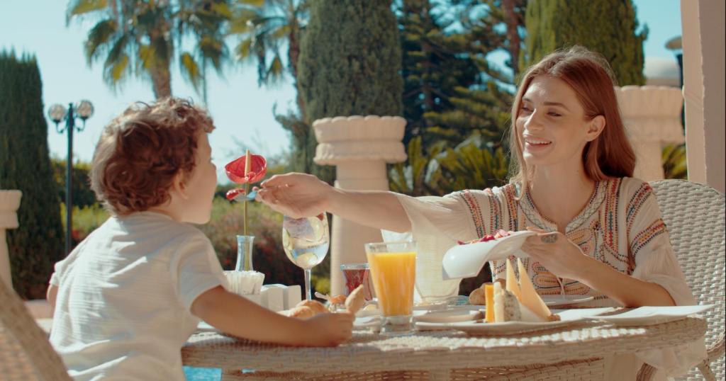 Brokastis pie Spice Hotel & Spa, sieviete pasniedz ēdienu bērnam.