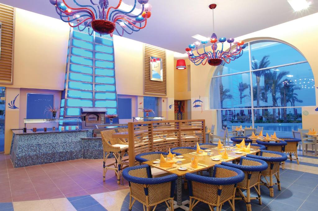 Restorāns Grand Rotana Resort & Spa ar krāsainu apgaismojumu un elegantiem galdiem