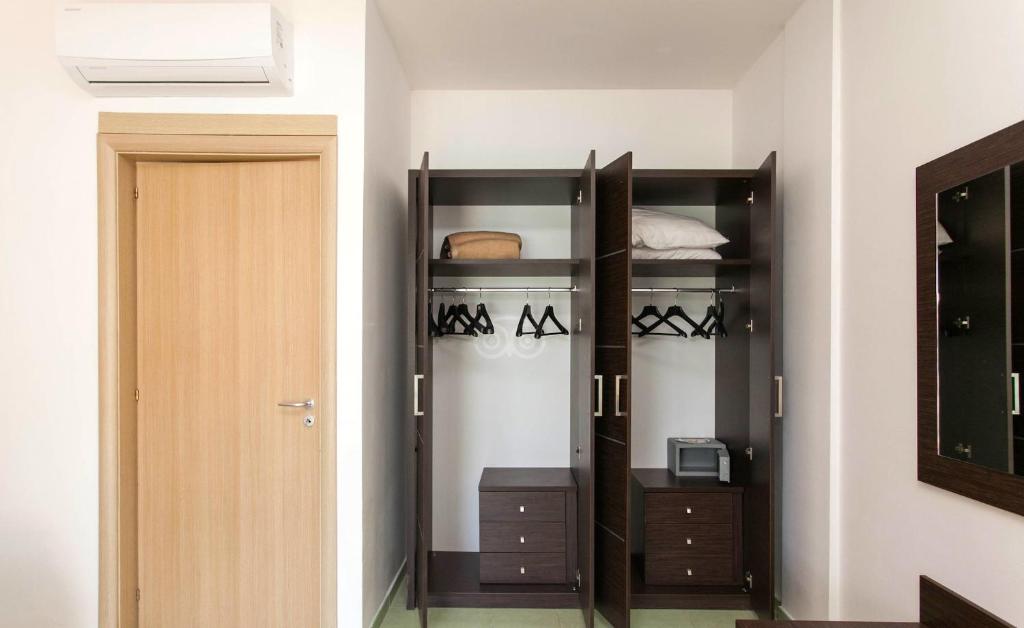 Praktisks drēbju skapis ar divām plauktiem, apģērbu pakaramiem un nelielu mikroviļņu krāsni. Telpa ar gaišu interjeru un dabiskiem apgaismojuma elementiem.