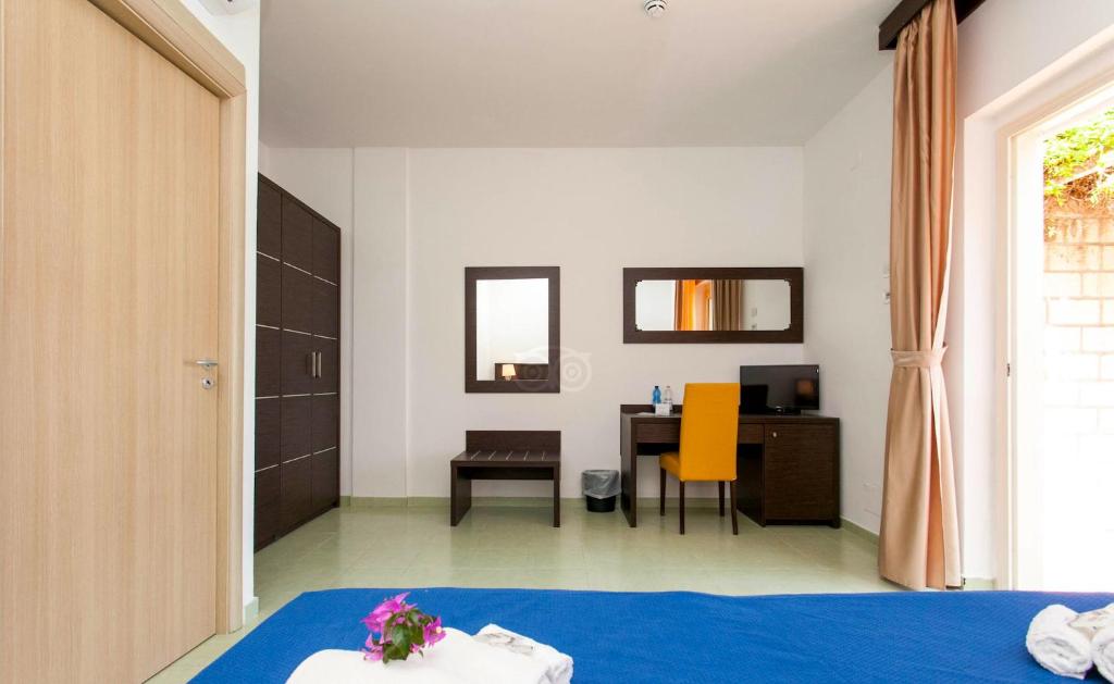 Gaišs un moderns viesnīcas numurs ar koka durvīm, tumšām mēbelēm un dzeltenu krēslu pie galda, kas nodrošina ērtu darba vietu. Numurā ir arī liels spogulis un plaukti, radot patīkamu un mājīgu atmosfēru.