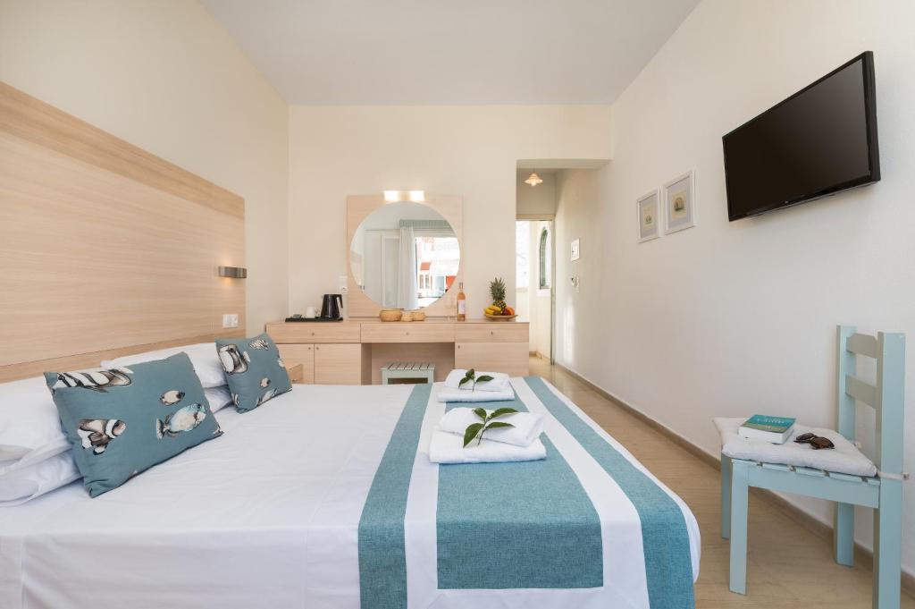 Mūsdienīga viesnīcas numura iekārtojums ar divguļamo gultu, dekoratīvām spilveniem un televizoru. Numurā ir arī rakstāmgalds un atpūtas zona ar ērtu krēslu.