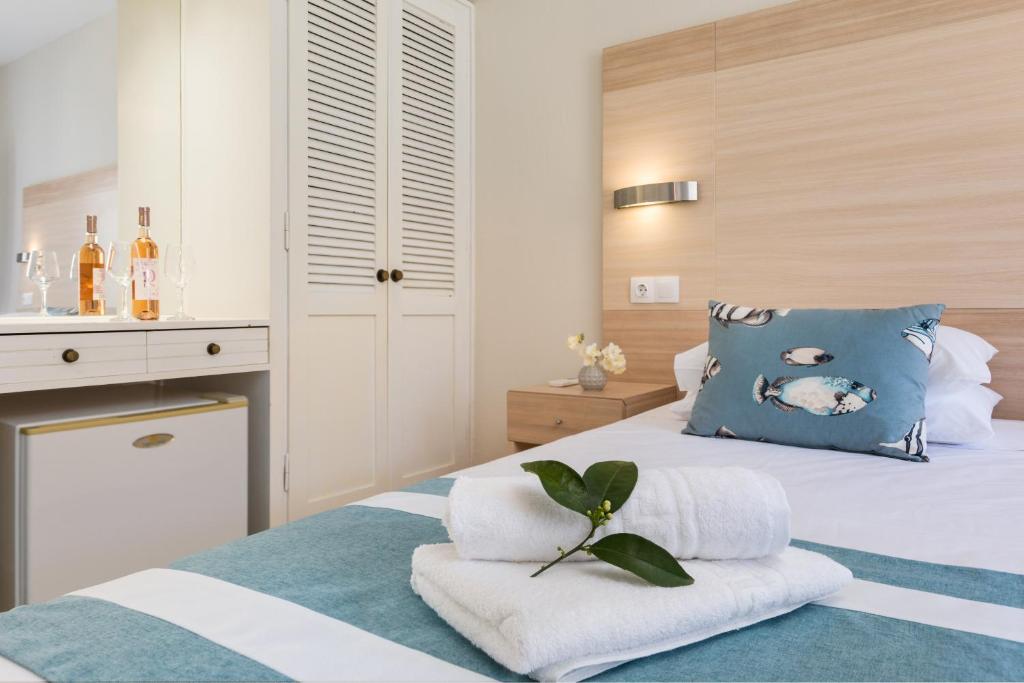 Mūsdienīga guļamistaba ar koka apdari, dekoratīvu spilvenu un svaigiem ziediem. Uz galda atrodas pudeles vīna un glāzes, radot relaksējošu atmosfēru.