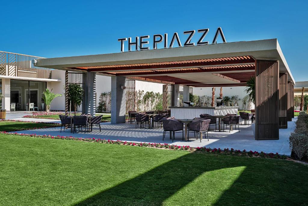 Mūsdienīgs āra kafejnīca ar nosaukumu "THE PIAZZA", kas piedāvā ērtas sēdvietas un skaistu ainavu, ieskaitot zālājus un ziedus.